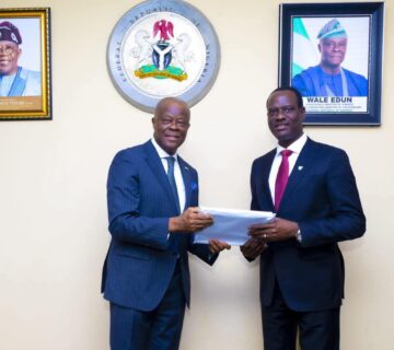 Mr Edun handing over the baton of office to Mr Oyedele 