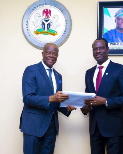 Mr Edun handing over the baton of office to Mr Oyedele.